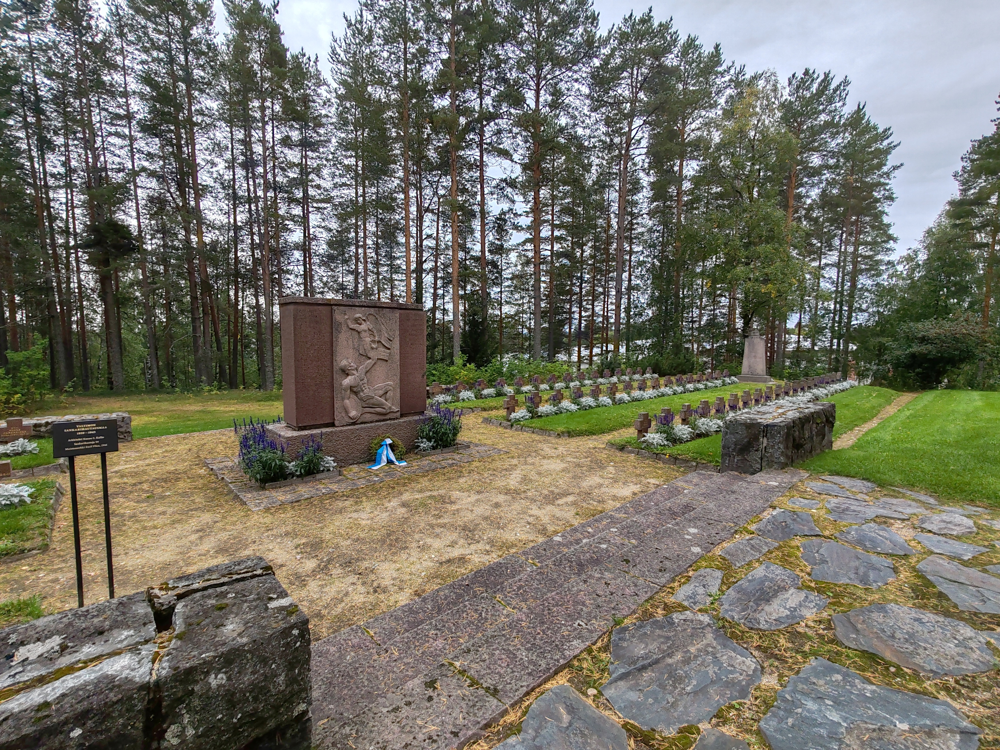 Valtimon sankarihautausmaa Kuvassa punagraniittinen muistomerkki ja pieniä kivisiä ristejä, Valtimon sankarihautausmaa.